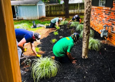 Pinstripe Lawn Care and Landscaping crew working flower beds.
