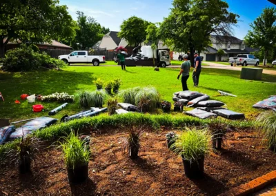 Pinstripe Lawn Care and Landscaping crew working flower beds and tree trimming.